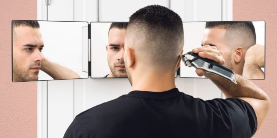 man giving himself a haircut with electric razor in three way mirror. For men who seriously need a haircut, it's time to take matters into your own hands. Check out products for a DIY haircut from Wahl, ArtNaturals and more.
