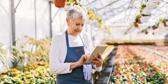 Woman holding a tablet in her garden