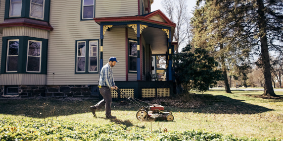 Mature man mowing grass on sunny day