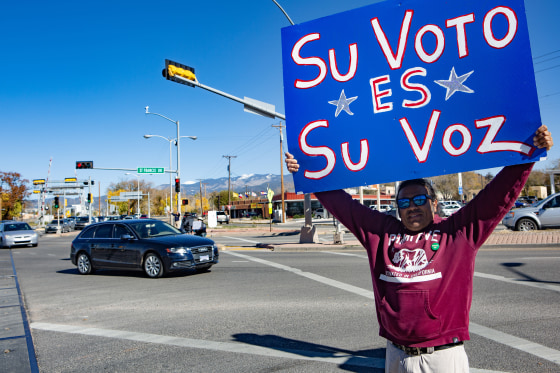 A man holds a Spanish-language sign, "Your vote is your voice," during the midterm elections in Santa Fe, N.M., on  Nov. 6, 2018.
