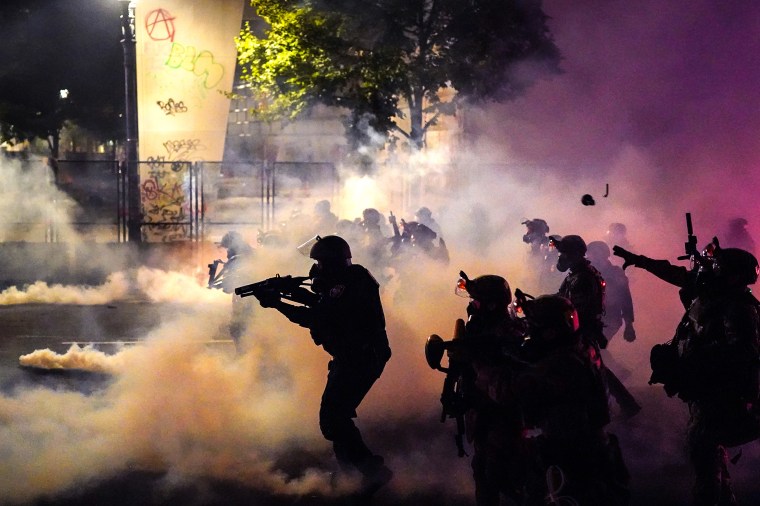 Federal officers deploy tear gas and less-lethal munitions while dispersing a crowd of about a thousand protesters in front of the Mark O. Hatfield U.S. Courthouse