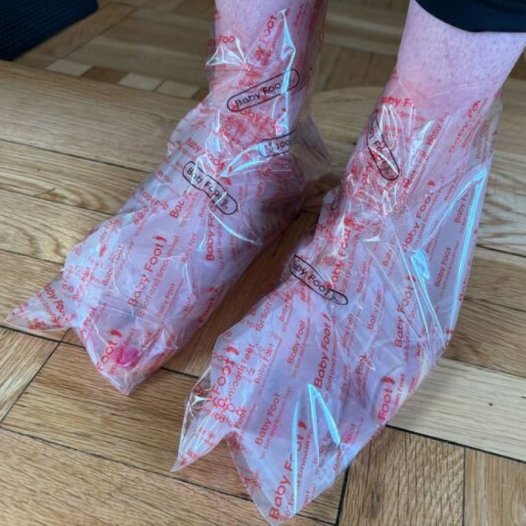 Staffer wearing the Baby Foot booties, which are and secured with the Baby Foot stickers that come in the set.