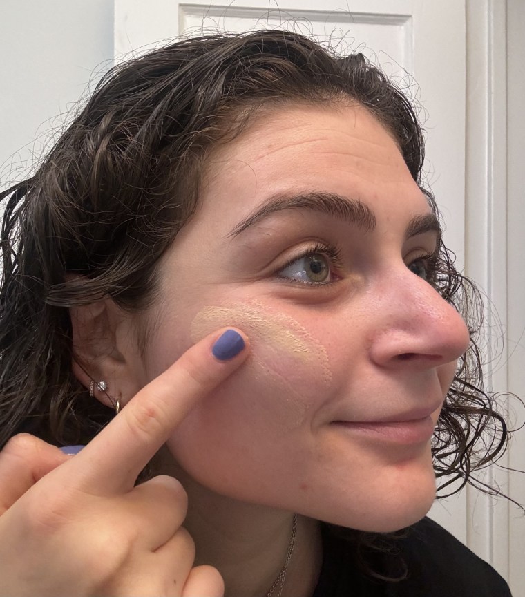 A woman applying Tower 28’s SunnyDays SPF 30 Tinted Sunscreen.