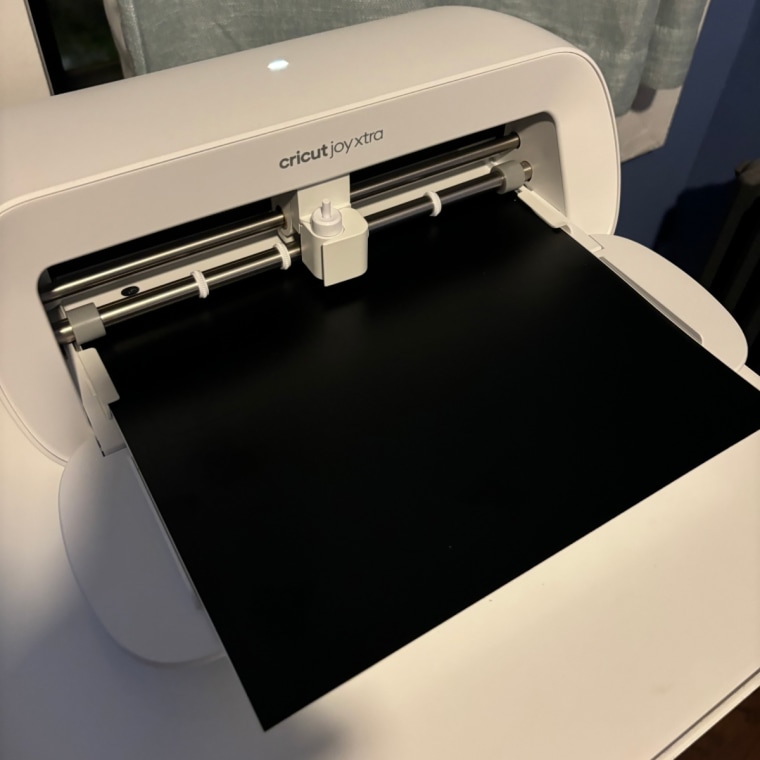 Cricut Joy Xtra sits on a desk with the front panel open.