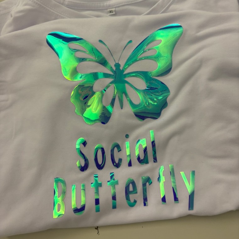 T-shirt with the words “social butterfly” ironed on the front and a butterfly on the top.