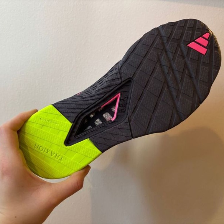 A pair of pink Adidas Dropset 3 training sneakers with the outsole facing up to show the airflow windows.