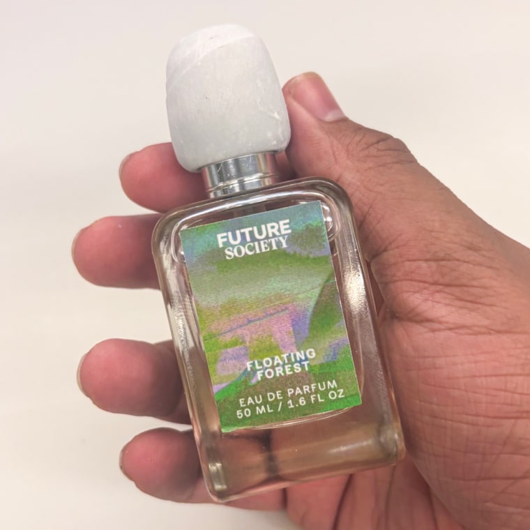 Person holding Future Society Floating Forest perfume in right hand.