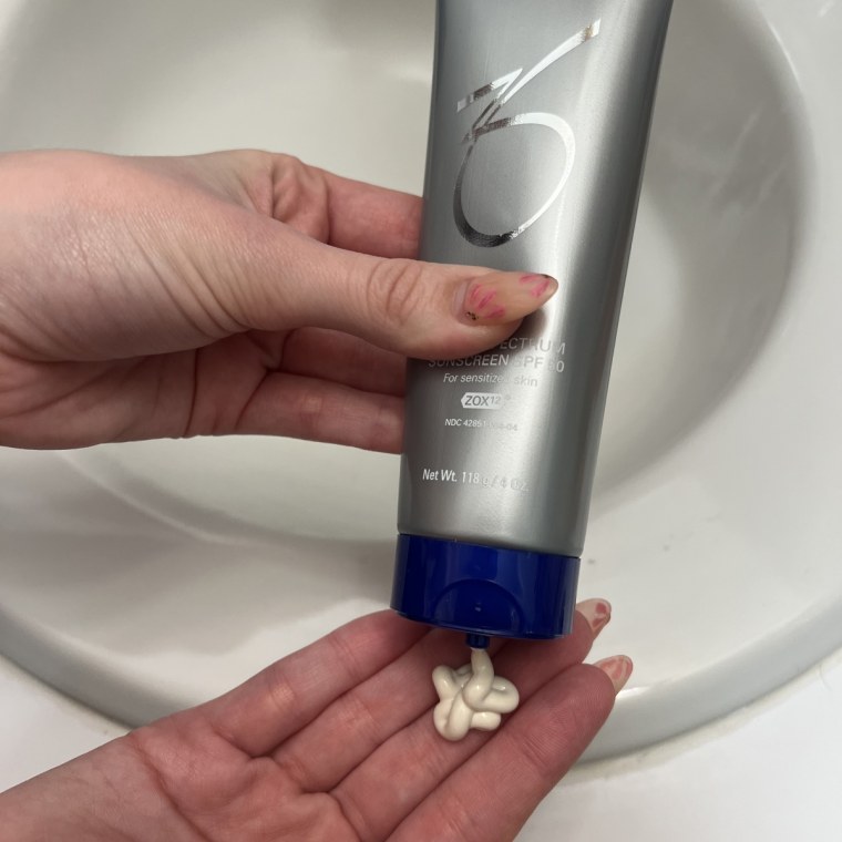 Woman applying sunscreen to her hand.