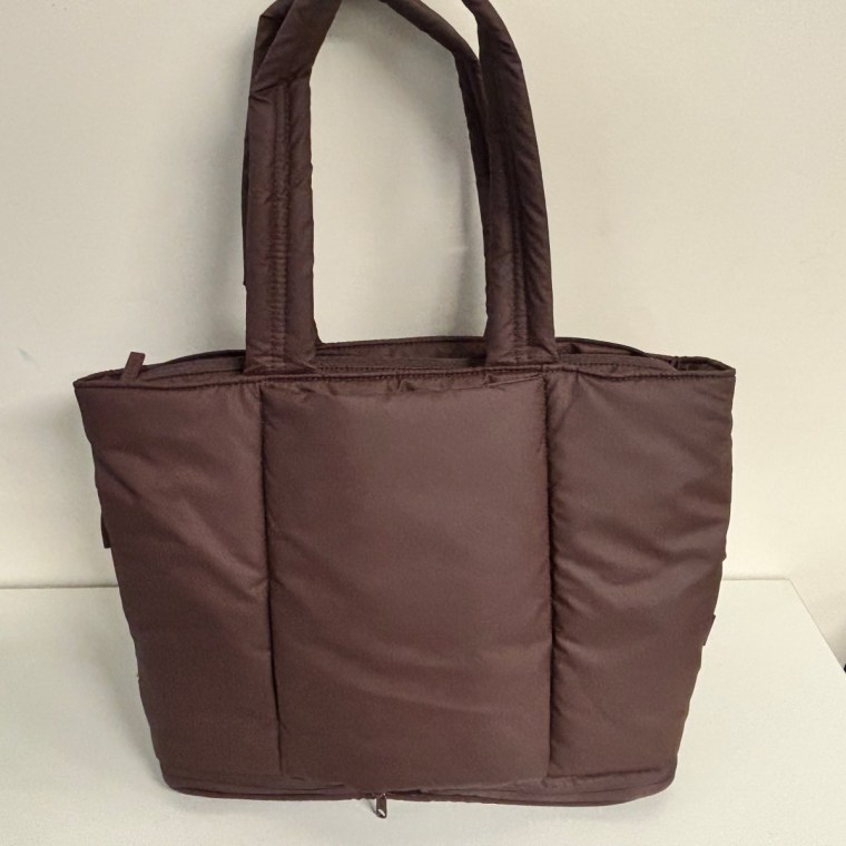 Calpak Luka Expandable Tote Bag in walnut sitting on surface.