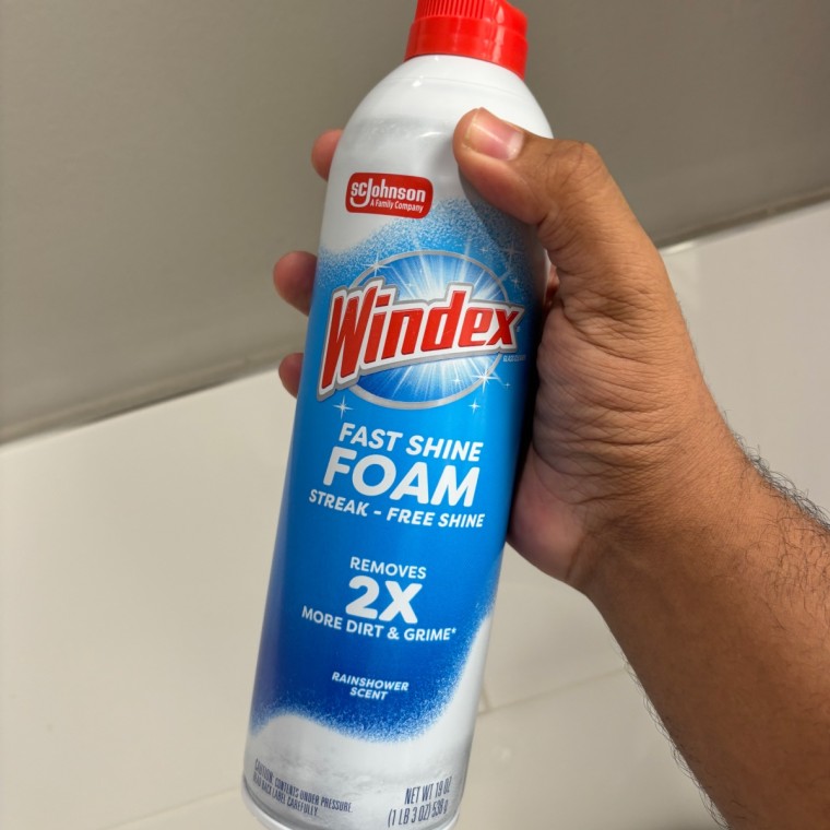 Man holding Windex Fast Shine Foam Glass Cleaner
