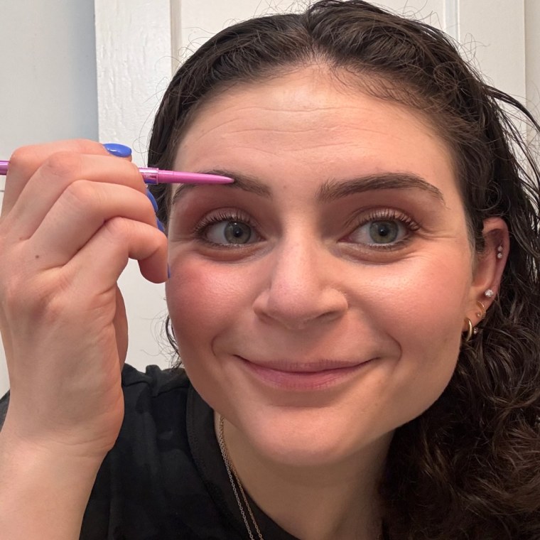 A woman using Kosas’ Brow Pop Nano.