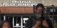 A Black police officer outside the Knoxville Police Department as a demonstrator speaks.