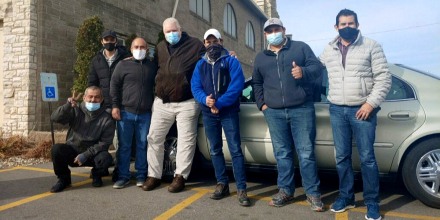 The six construction workers from Texas who stopped receiving pay for their work in Cedar Rapids, Iowa flank John Greve, pastor of Grace Episcopal Church, who fed and housed them after the learning of their situation.