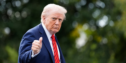 Donald Trump walks and gives a thumbs up