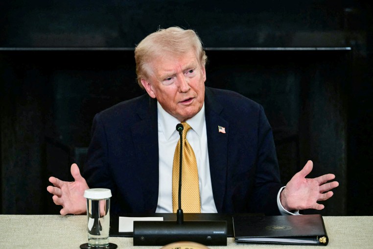 Donald Trump speaks while seated at a table